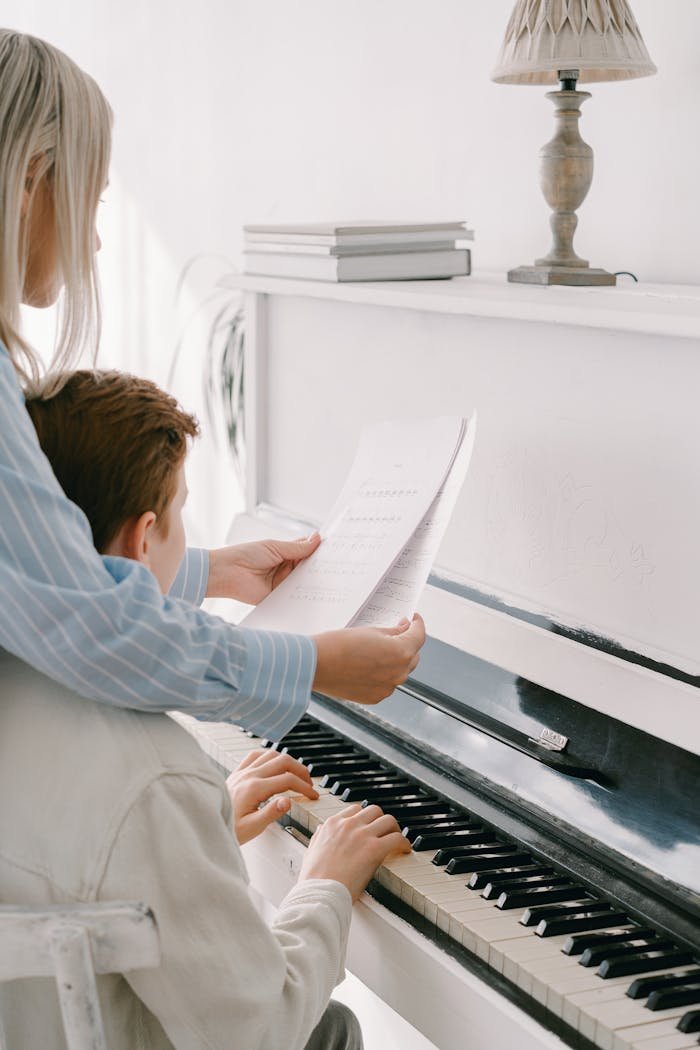 Focused piano lesson with a young student learning from a teacher in a bright setting.